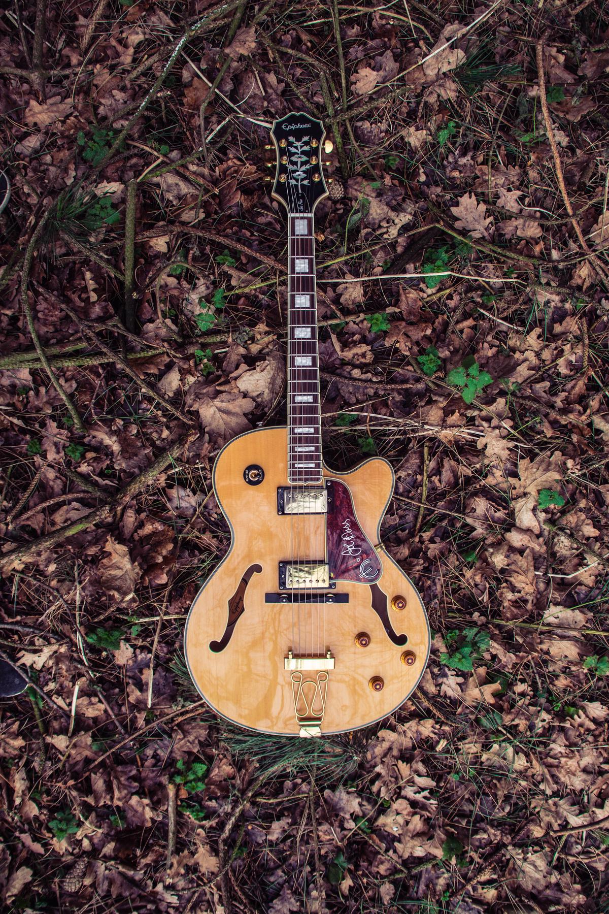 A vintage Gibson guitar resting on a guitar stand, showcasing its timeless beauty and craftsmanship.