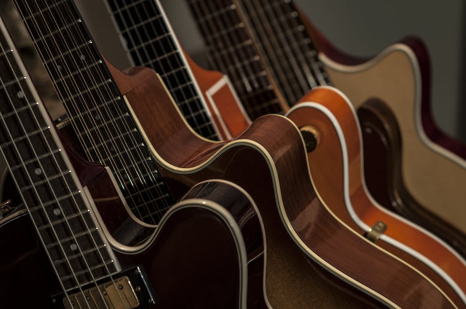 A close-up image of a Gibson guitar with the Gibson logo visible on the headstock and the strings in focus.
